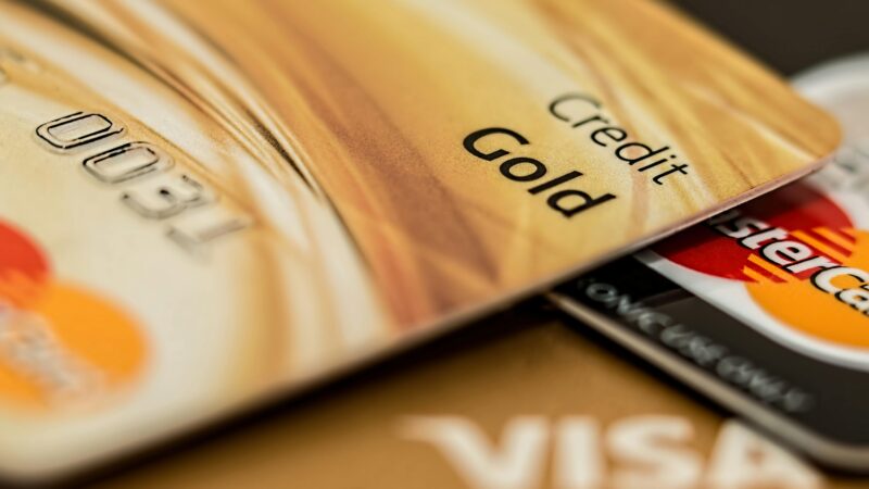 Stack of various branded credit cards focusing on gold card showing finance and cashless concept.